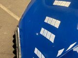a close up of a blue car parked in a parking lot