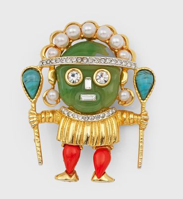 un gros plan sur une broche verte et rouge ornée de perles