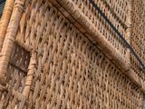 a wicker basket with a handle on the back of it