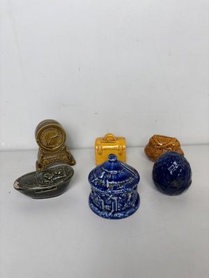 trois petits objets en céramique bleus et jaunes sont posés sur une surface blanche