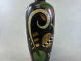 un vase noir avec un motif sur fond blanc