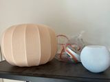 a table with a vase, a speaker and a lamp on it