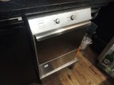 a stainless steel oven in a kitchen with a black counter top