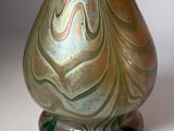 a green vase with a swirly design on it