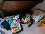 un tas d'objets posés par terre sous un lit