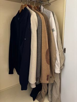 a lot of clothes hanging on a rack in a closet