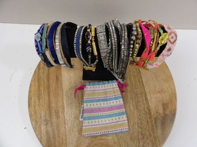 many different bracelets on a wooden plate on a table