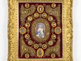 un cadre doré richement décoré, dans lequel figure le portrait d'une femme et d'un enfant