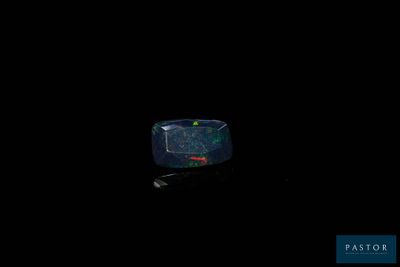 a clock that is on a black surface in the dark