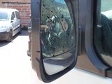 a white van with bullet holes in the side view mirror