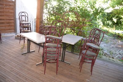 de nombreuses chaises et tables sur la terrasse de cette maison
