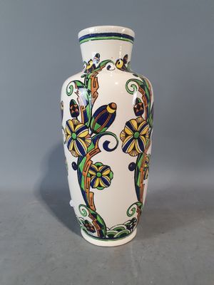 un vase blanc orné d'un motif bleu et jaune