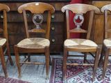 Quatre chaises en bois sont alignées sur un tapis dans une pièce