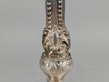 a close up of a silver candle holder on a table