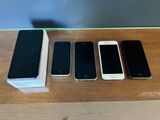 Trois iPhones sont posés sur une table à côté d'une boîte