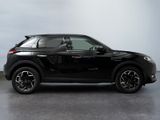 the black suv is parked in a room with a white wall