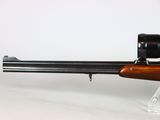 a close up of a rifle with a scope on a white background
