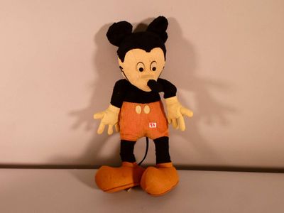 mickey mouse plush toy sitting on top of a white surface