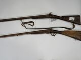 three old guns are displayed on a wall in a room