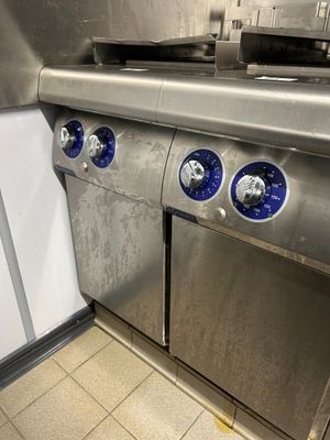 three blue knobs on the side of a stainless steel stove