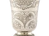 vase en argent orné d'un motif élaboré sur un socle, sur fond blanc