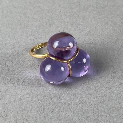 un gros plan d'un anneau violet sur une surface grise