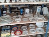 many plates and bowls on the shelves in the room