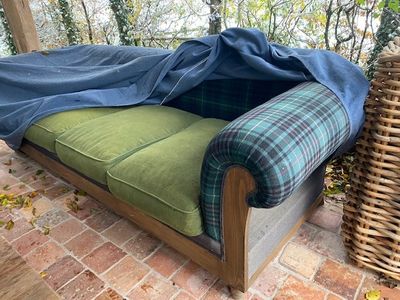 un canapé recouvert d'une couverture, installé sur une terrasse