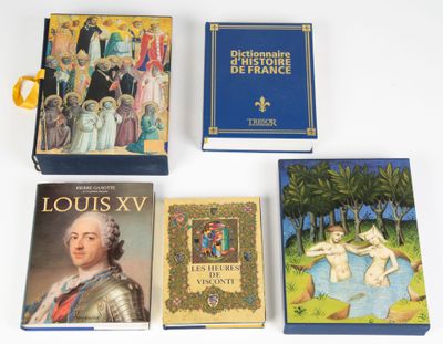 Quatre livres sont posés sur une surface blanche ; l'un d'entre eux est bleu et un autre est doré.