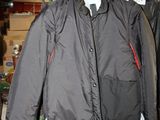 deux vestes suspendues à une étagère en bois dans une pièce