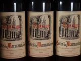 several bottles of red wine are lined up on a shelf