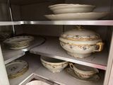 de nombreuses assiettes et bols sur les étagères du placard