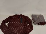 un pull et un sac posés sur une surface blanche