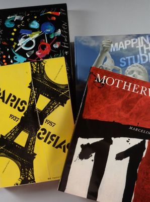 trois livres sont posés sur une table recouverte d'une nappe blanche