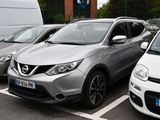 plusieurs voitures garées sur un parking à côté d'une camionnette blanche
