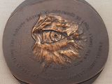 une plaque en bronze sur laquelle est représenté un œil