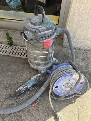 un aspirateur posé par terre à côté d'un tuyau