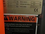 a warning sign posted on the side of a machine