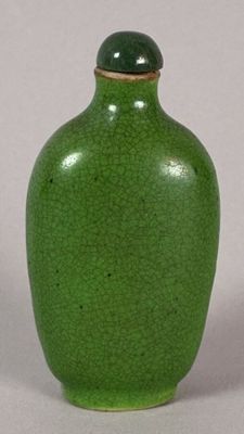 a green vase with a lid sitting on a table
