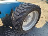 a tractor tire that is sitting on the side of the road