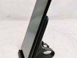 the phone is sitting on the stand on the table