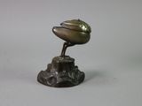 a bronze statue of a bird on top of a tree stump
