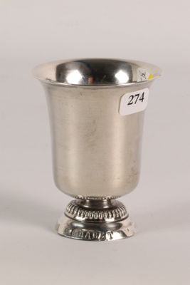 an antique silver cup with a label on the side