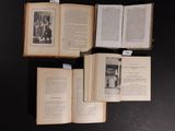 several open books on a black table with pictures of people on them