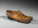 an old wooden shoe with a foot on it on a table