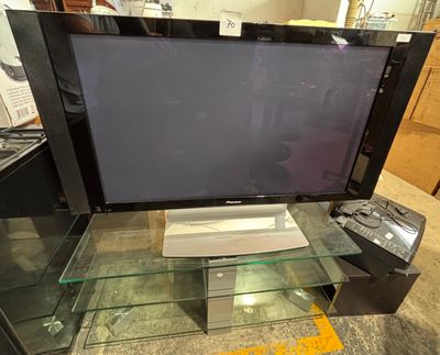 a flat screen tv sitting on top of a glass table