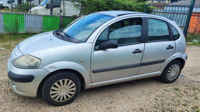 a small silver car parked on the side of the road