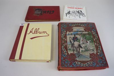 Plusieurs livres sont posés sur une table blanche, dont l'un a une couverture rouge.
