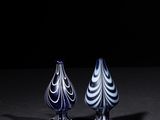 two blue and white vases sitting on top of a black table