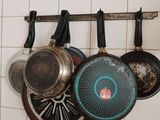des casseroles et des poêles suspendues à un support dans une cuisine